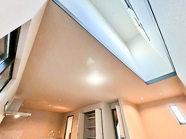 【リビング】住まいの開放感を最大化するダイナミックな吹抜け空間。上部に設けたハイサイドライトから、時間とともに移り変わる自然光がたっぷりと差し込みます。