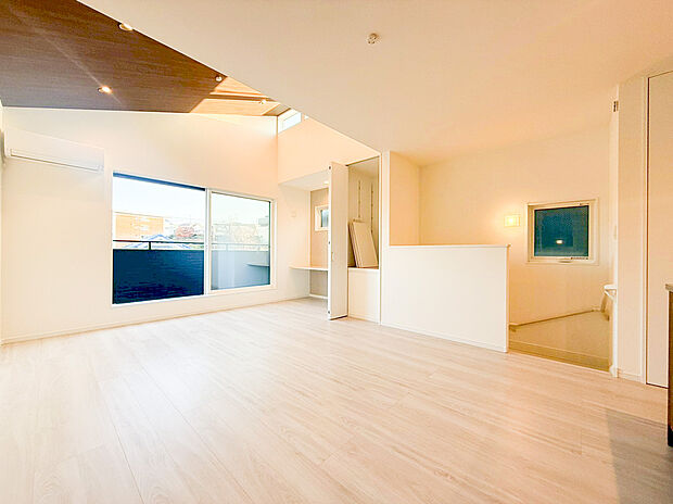 【リビング】広々とした開口部と高窓から自然光がたっぷりと差し込む、明るいLDKです。ダイニングやキッチンと一体となった開放的な空間は、ご家族のコミュニケーションを育みます。