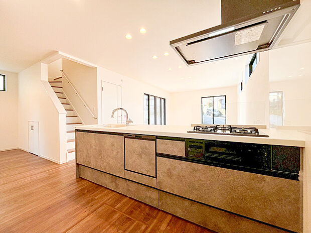 【キッチン】家具のような美しさを放つ、洗練されたデザインのオープンキッチンです。お料理中もリビングでくつろぐ家族や、南西向きの窓から差し込む陽光を感じられる開放的な設計が魅力。