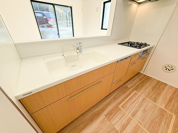 【キッチン】清潔感のあるホワイトのワークトップに、収納力抜群のシステムキッチンを採用 。面倒な後片付けをサポートする食洗機や、広々としたシンクが日々の家事をバックアップします 。