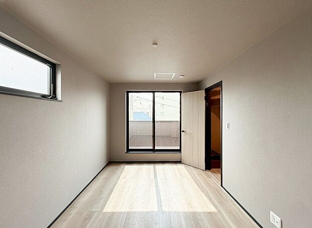 【洋室】明るく開放的な空間が広がる居室は、二面採光による心地よい光と風が通り抜ける設計です 。木のぬくもりを感じる明るいフローリングと落ち着いた色調の壁紙が、上質なリラックスタイムを演出します 。