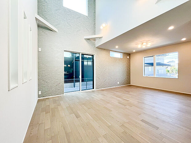 【リビング】光と開放感に満ちた、贅沢な吹き抜け空間！ ダイナミックな高天井と高窓が、住まいの中心に明るい光と心地よい風を届けます。