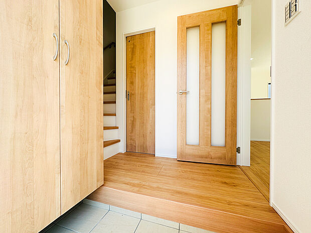 【玄関】【玄関からリビングへのスムーズな動線】明るく開放的な玄関ホール。木の温もりを感じる建具が、住む人を優しく迎えてくれます。帰宅後すぐにリビングへアクセスでき、家族のコミュニケーションも円滑に。