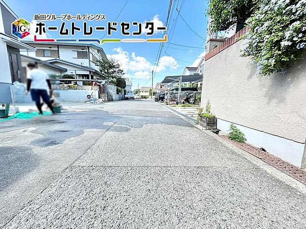 【前面道路含む現地写真】道路幅は約６ｍあるので、運転が苦手な方でも楽々駐車できます♪電柱から建物まで距離があるのは、防犯面でも良いポイントです。