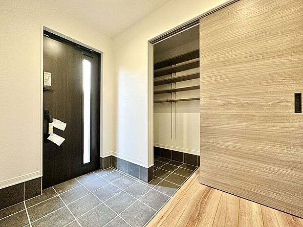 【玄関】広いシューズクロークで玄関がすっきり。スノーボード、キャンプ用品などの大型荷物もしまえます。また通り抜けができる為、靴が散らかないのも魅力◎