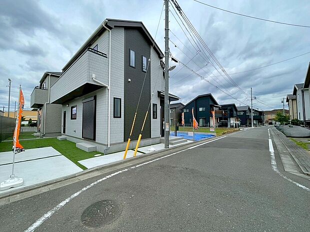 外観画像:ゆとりある舗装道路に面した角地の二階建て住宅。カースペース1台分と整えられた外構があり、落ち着いた街並みに溶け込むモダンな佇まいが日々の暮らしに安らぎをもたらします。