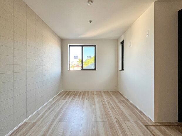 【居室6.0帖】アクセントクロスがおしゃれな明るい居室。大きな窓から陽光が差し込み、ゆったりとしたプライベート空間を演出します。