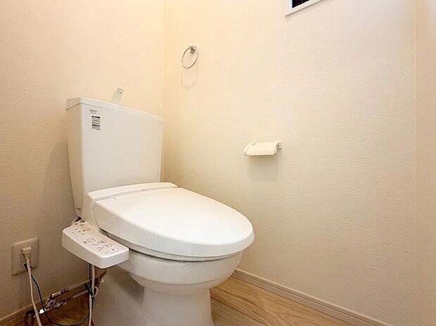【トイレ】白を基調とした清潔感あふれるトイレ空間。温水洗浄便座付きで、毎日快適にお使いいただけます。手触りの良い木目調の床が優しく落ち着いた雰囲気を演出。小窓からの自然光が明るさをプラスします。