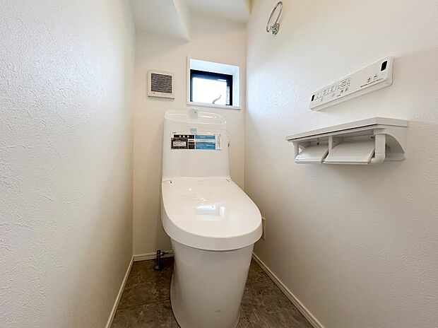 【トイレ】小窓から自然光が差し込む、明るく清潔感のあるトイレ空間です。お手入れがしやすいフォルムの便器を採用。便利な棚付きのペーパーホルダーも備わっており、快適に毎日お使いいただけるプライベート空間です。