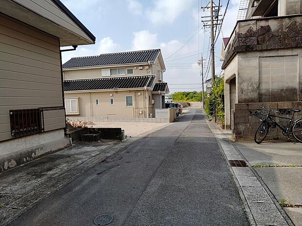 【前面道路含む現地写真】幅約4mのアスファルト道路に面した落ち着いた住宅地で、両側に戸建てが並ぶ平坦な通りは自転車や歩行者の往来もしやすく、穏やかな暮らしが期待できます。