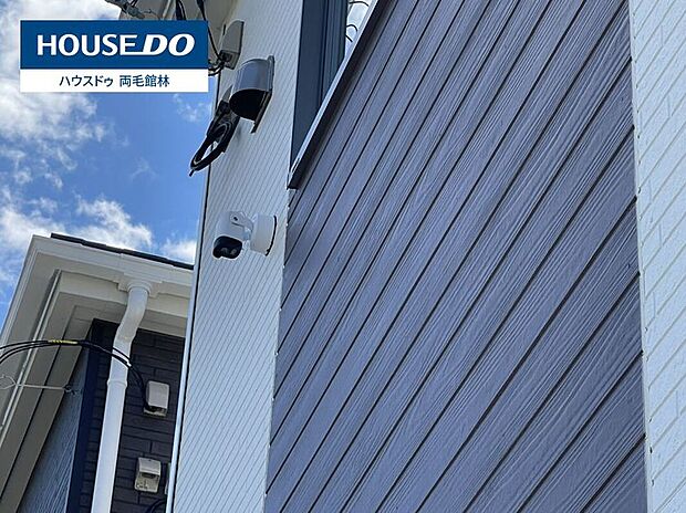 【2号棟 防犯カメラ】2号棟。外壁に防犯カメラを設置し、住まいの周囲をしっかり見守ります。防犯意識の高い住まいで、お子さまの留守番時や長期のお出かけの際も安心して過ごせます。