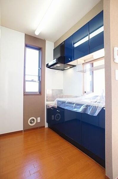 画像10:ビビッドな青いパネルを採用したキッチン♪側面にも採光と換気を考慮した窓を配し、明るく快適な空間♪