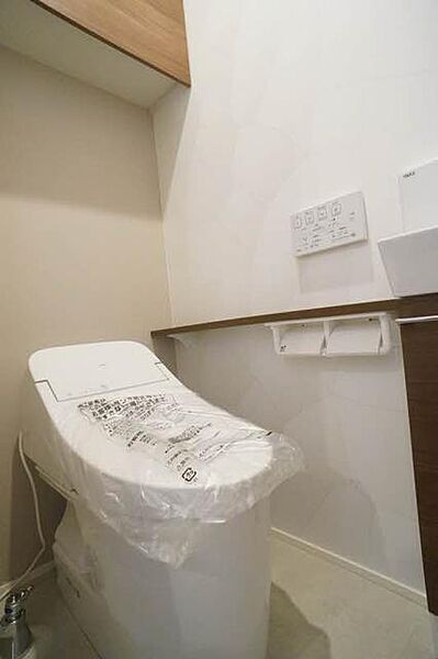 画像14:【トイレ】リモコン式暖房洗浄便座のあるトイレです。スッキリとしたデザインで、上部の棚や手洗いも付いています。アクセントクロスも貼られたオシャレな空間になっています。