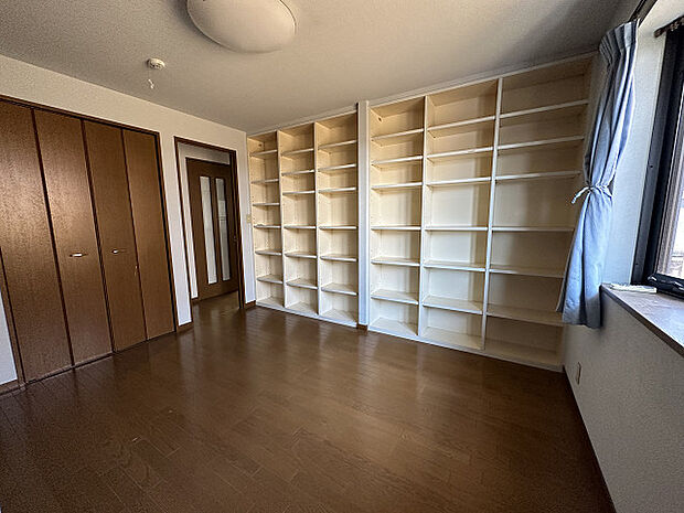 【2階洋室/収納】壁一面に広がる収納棚。本を並べたり、衣類を収納したりする事ができそうです。趣味の物を並べて、お好きな空間にカスタマイズする事も◎