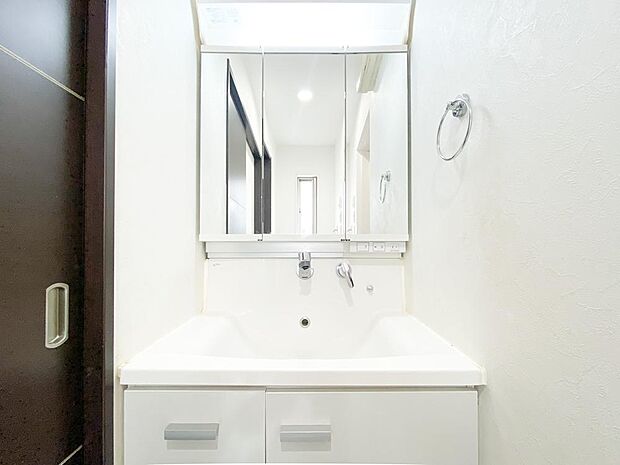 清潔感のある白を基調とした洗面化粧台です。三面鏡の裏にある収納で細々したものをしっかり片づけることができます。