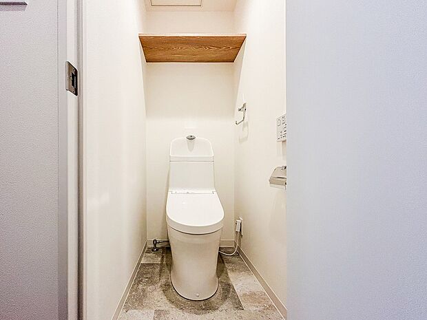 清潔感あふれるウォッシュレット付きのトイレです。上部木目の棚がワンポイントです。