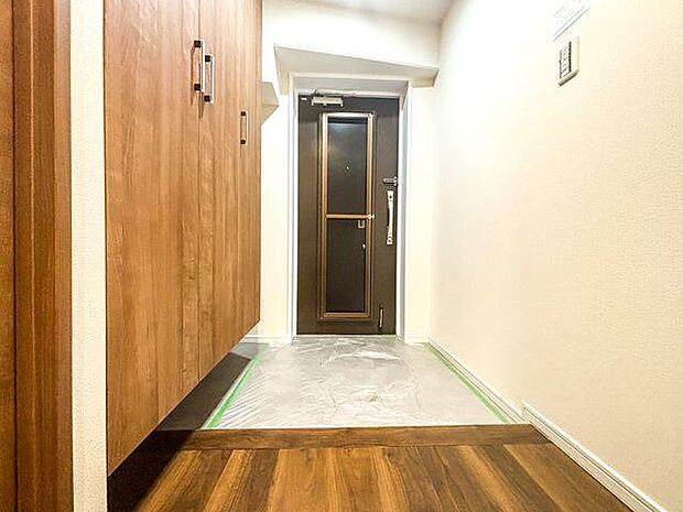 玄関はシンプルなデザインになっております。横の収納スペースは靴の整理などに便利ですね。
