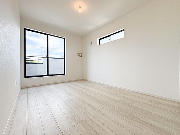 2面の窓から明るい陽光が降り注ぐリビング。家族が自然と集まる、心地よい空間です。