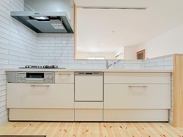 清潔感ある白基調のシステムキッチン。食洗機や収納も備わり、使い勝手の良さとデザイン性を両立。家事を効率的にサポートします。