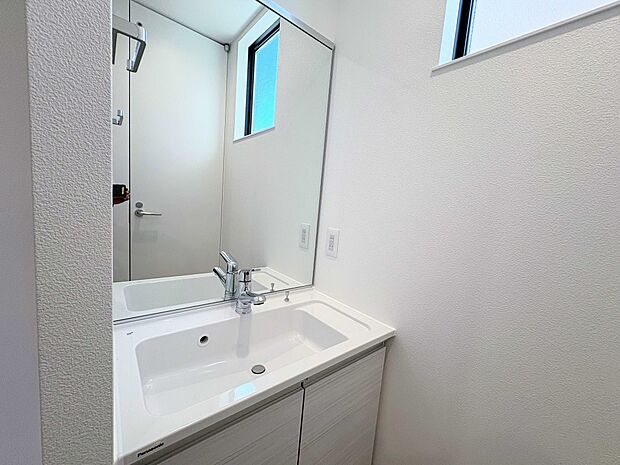 明るい光が差し込む清潔感あふれる洗面所。大きな鏡で朝の準備もスムーズに。Panasonic製の洗面台は機能性もで、家族みんなが快適に使えます。