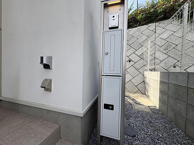 洗練されたデザインの門柱には、不在時も安心の宅配ボックスと、防犯カメラ付きインターホンを設置。ご家族の安全と快適な暮らしをサポートするエントランスです。