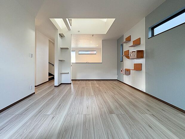 陽光溢れる吹き抜けのLDK。明るい木目と白い壁が調和し、家族の笑顔が集まる空間。