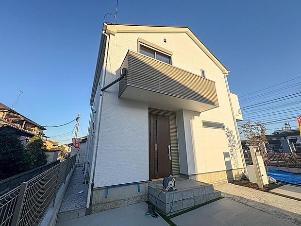 陽光が降り注ぐ、白と木目のコントラストが美しいモダンな外観。家族の成長を見守る、明るく開放的な新生活がここから。