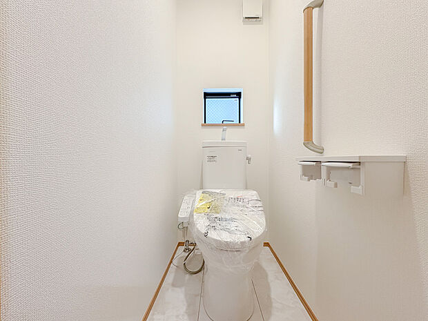 ウォシュレット付きのトイレは、全体が白を基調としたデザインで統一されており、清潔感と爽やかさを感じさせます。