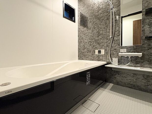 一日の疲れを癒すバスルーム。重厚な石目調の壁とゆったり浴槽（LIXIL製）で、上質なリラックスタイムを。
