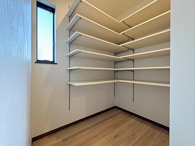 キッチン横に大容量パントリー。窓付きで明るく換気も良好。可動棚で食品ストックをすっきり整理。