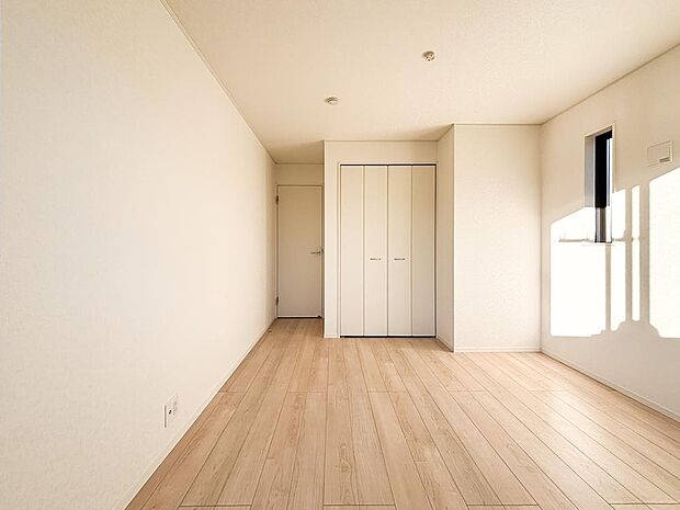 陽光差し込む明るい洋室。木目調フローリングと白壁が清潔感を演出する、心地よいプライベート空間です。