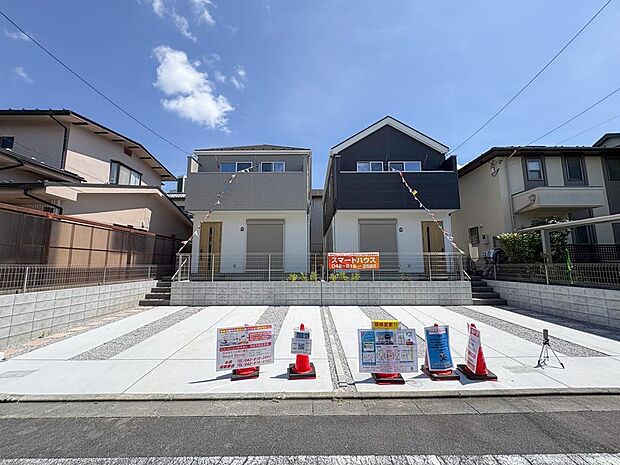 青空に映えるモダンなデザインの新築戸建てが並びます。広々とした駐車スペースは、お車の出し入れもスムーズで、家族の新しい生活を快適に彩ります。