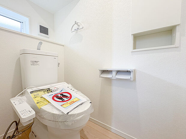 ウォシュレット付きのトイレは、全体が白を基調としたデザインで統一されており、清潔感を感じさせます。