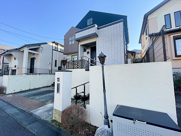 道路からの高低差を活かし、通行人の視線が気にならないプライバシーに配慮した設計です。玄関アプローチには重厚感のある石畳と手すり付きの階段を採用し、防犯性と高級感を両立。