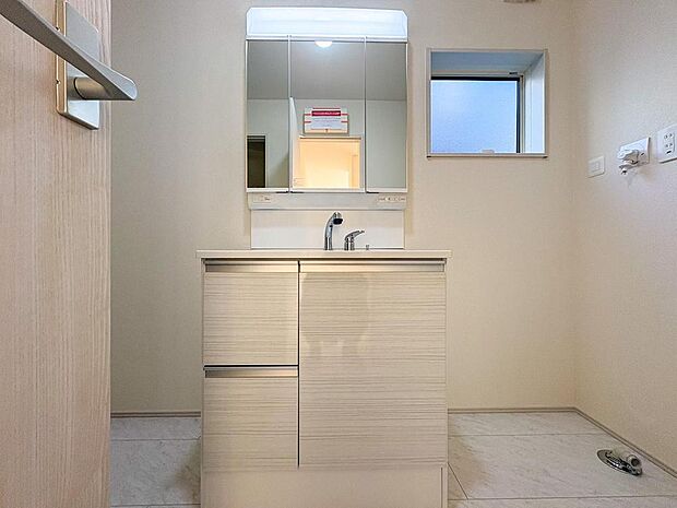 三面鏡裏収納付きの洗面化粧台は、家族の身支度をスムーズに。小窓から光が差し込み、明るく清潔感あふれる洗面所です。