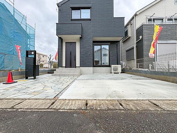 スタイリッシュな外観が目を引く、モダンな住まい。広々とした駐車スペースと美しいアプローチが、家族の帰りを温かく迎えます。