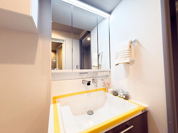 大型ミラーを備えた、明るくスタイリッシュな洗面化粧台。