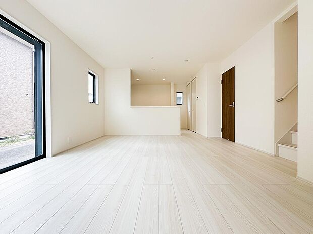 大きな開口部から光が差し込む明るいリビング。広々とした空間で家族がゆったりと過ごせる快適な住空間です。