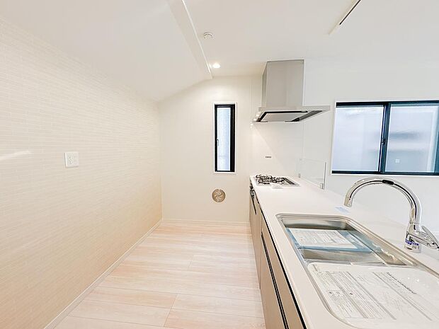 キッチン背面には、洗練されたタイル調のアクセントクロスを採用。上品で明るい空間を演出しつつ、汚れが付きにくくお手入れも簡単です。窓からの自然光も入り、毎日の料理が楽しくなる機能的でお洒落な空間です。