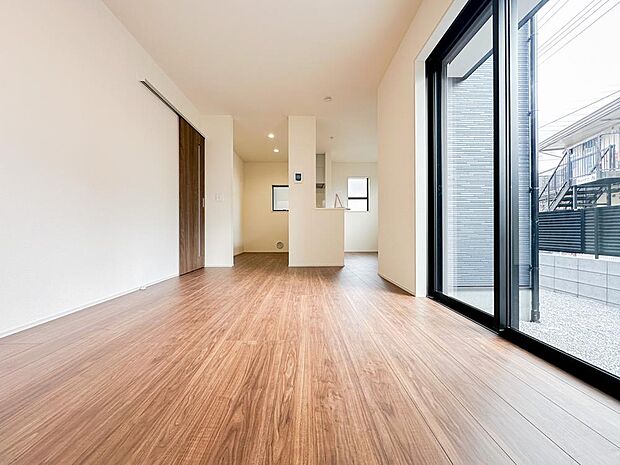 大きな掃き出し窓から光が差し込む明るいLDK。庭へとつながる開放的な設計で、室内にいながらも外との一体感を感じられる心地よい空間です。