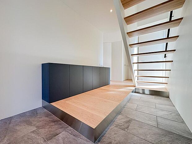 段差を活かした玄関スペースと収納を一体化。シンプルながらデザイン性の高い空間構成で、日常の使いやすさと美しさを両立しています。