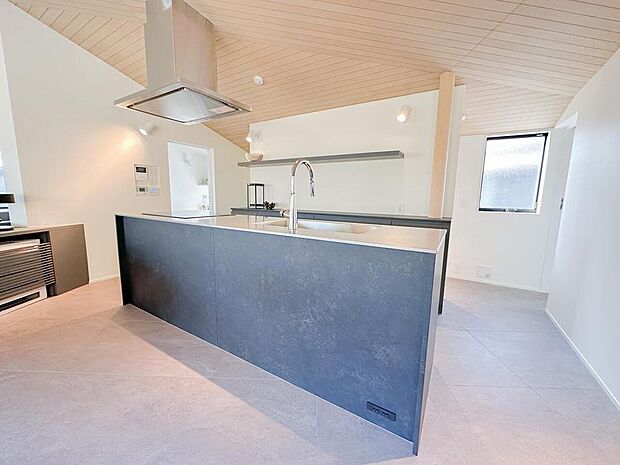 重厚感あるアイランドキッチンが主役の空間設計。回遊動線で使いやすく、料理をしながら家族との会話も楽しめる開放的な住まいです。