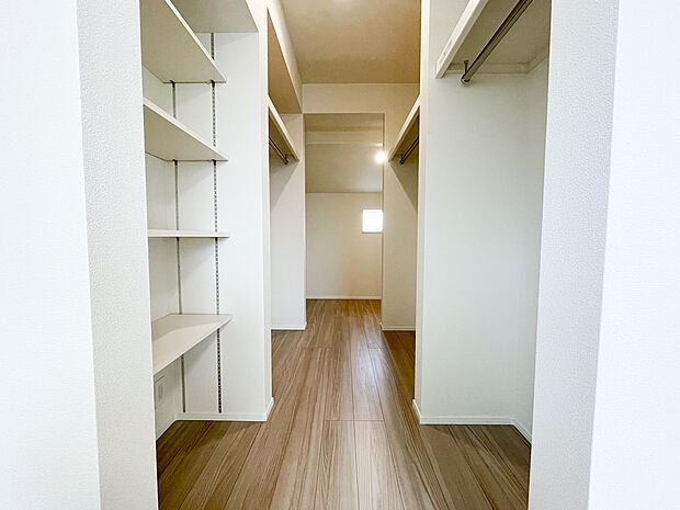 主寝室から繋がるウォークインクローゼットは、ハンガーパイプと可動棚を組み合わせたシステム収納。夫婦二人の衣類はもちろん、季節家電や旅行用バッグも余裕で収まる広さです。