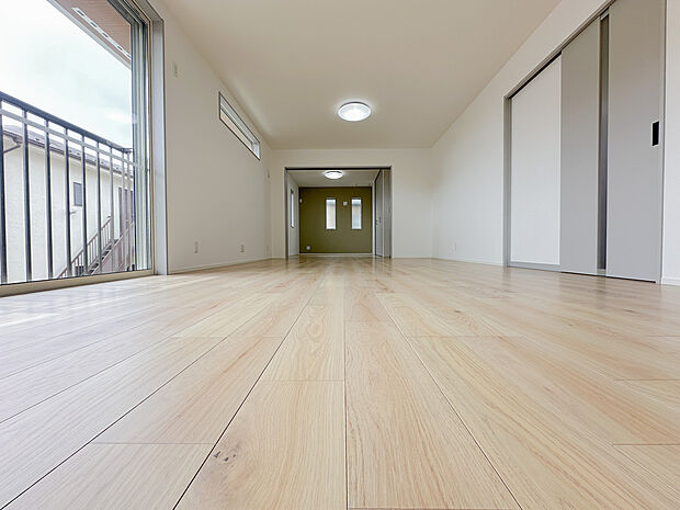 大きな掃き出し窓から光が差し込む開放的なLDK。家具配置もしやすい整形の空間で、家族が自然と集まる居心地の良いリビングです。