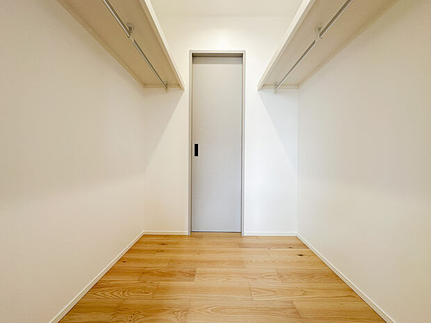 たっぷり収納できるウォークインクローゼット。左右にハンガーパイプを設け、衣類を分類して整理できる機能的な空間です。