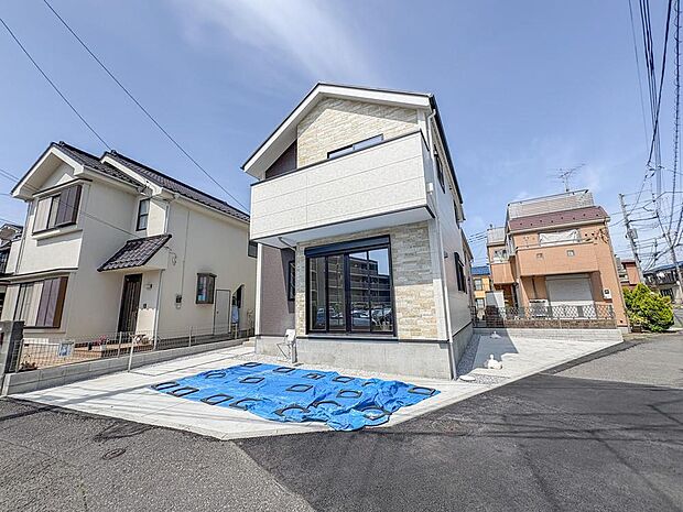 青空に映える、洗練されたデザインの新築戸建て。ゆとりのある駐車スペースは、家族のカーライフを快適にし、日々の暮らしに安心と利便性をもたらします。