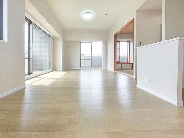 南西向きの大きな開口部からたっぷりの陽光が差し込む明るいリビング空間です。フルリフォーム済でフローリングやクロスも一新され、清潔感のある室内で快適にお過ごしいただけます。