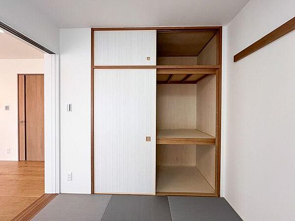 和室の押入れを開けた状態です。中段と天袋（上部の収納）に分かれた使いやすい設計は、かさばるお布団の収納やお子様のおもちゃ箱、季節物の衣類ケースなどを仕舞うのに非常に優秀です。