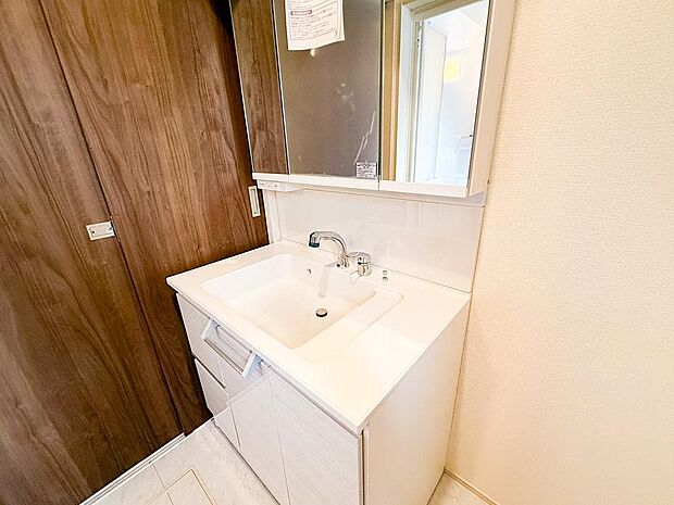 三面鏡付きの広々とした洗面台は、朝の身支度もスムーズに。収納力も高く、家族みんなのアイテムをすっきり整理できます。