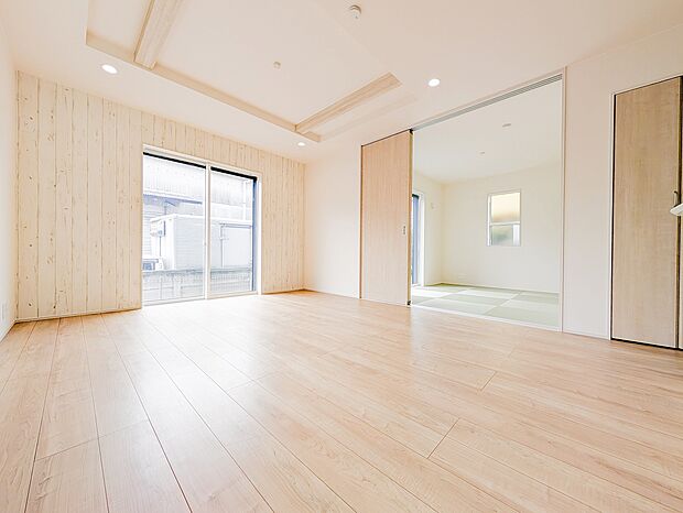 木目調アクセントクロスが印象的なリビング。遊び場や来客時に便利な和室が隣接しています。